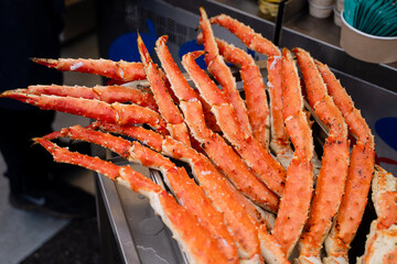 On a silver metal tray, there is a delightful assortment of succulent crab legs, just waiting to be savored and enjoyed by those who appreciate exquisite seafood dishes and flavors