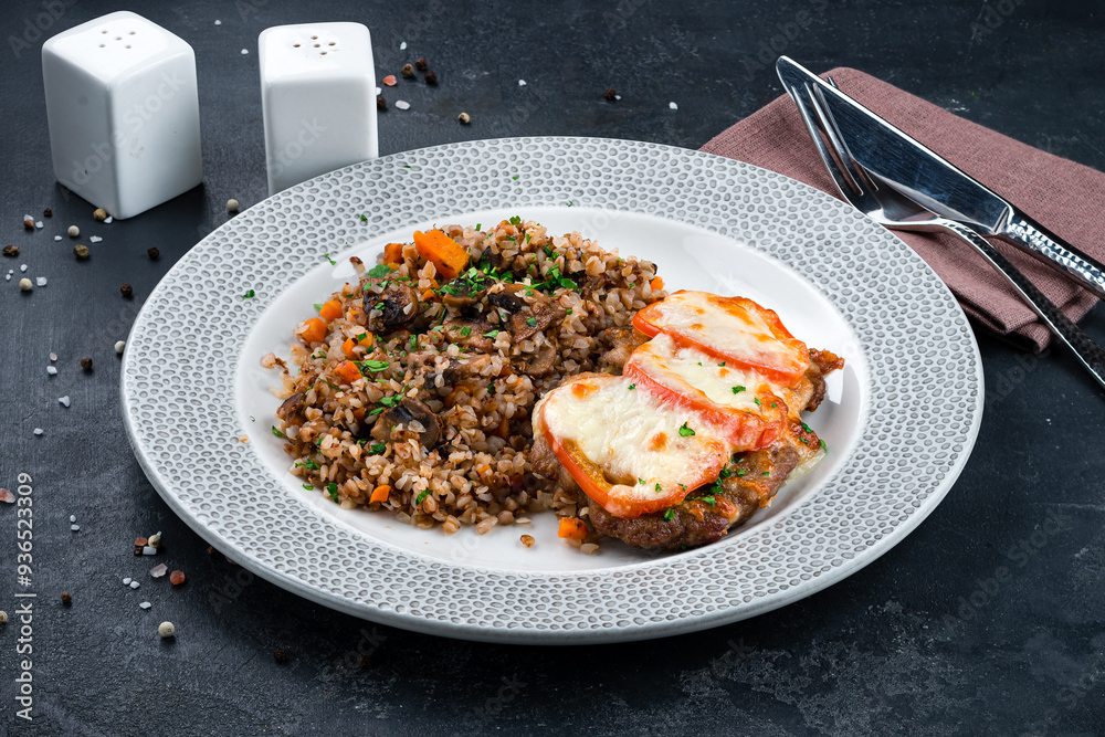 Poster Fried beef with tomatoes and cheese and buckwheat porridge with mushrooms, onions, carrots and herbs.