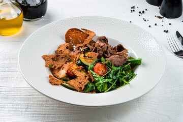 Lunch meat salad with beef slices, cherry tomatoes, zucchini, spinach, lettuce, bread and Dijon mustard.