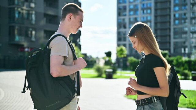 Cheerful teenagers friends guy and girl having fun dancing laughing outdoor