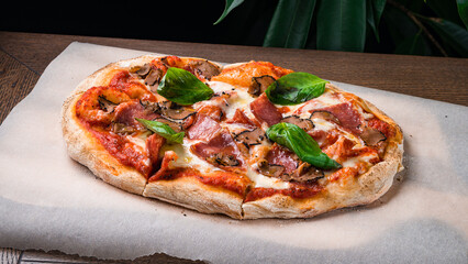 Italian cuisine pizza with bacon, cheese, truffle mushrooms and basil on a thick dough.