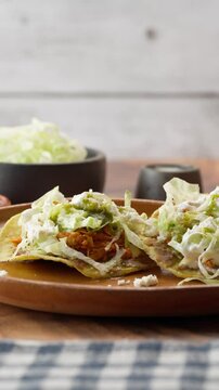 Slow vertical video, Mexican food served on a clay plate, tinga tostadas