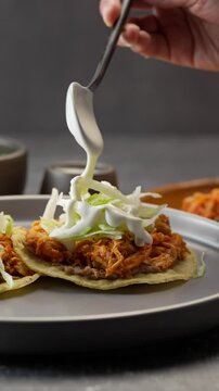 Vertical food video, pouring cream on a mexican tostadas