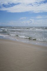 Wellen brechen an einem sonnigen Sommertag am Sandstrand von Sandhammaren in Ystad