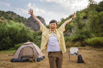 Obraz premium Portrait of mature japanese woman stand in front a tent in the forest