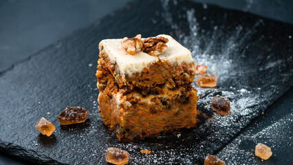 Piece of carrot cake with cream cheese, raisins and walnuts.