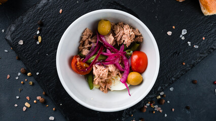 Salad with tuna, cherry tomatoes, red onion, olives, eggs and green beans.