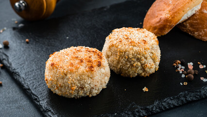 Fried pork cutlet with salt and pepper on a dark background.