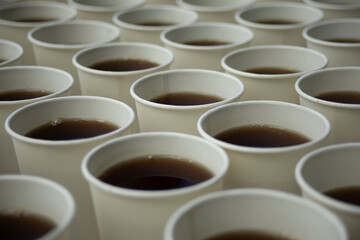 Tea in glasses. Lots of white drinking glasses. Tea on the street.