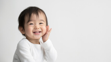 Fröhliches Asiatisches Kleinkind posiert im Studio für Werbeaufnahmen