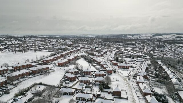 Aerial Drone Video Footage showing a snowy landscape in a suburban UK town.