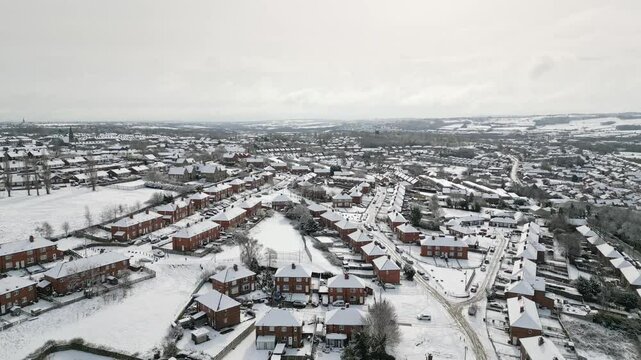 Aerial Drone Video Footage showing a snowy landscape in a suburban UK town.