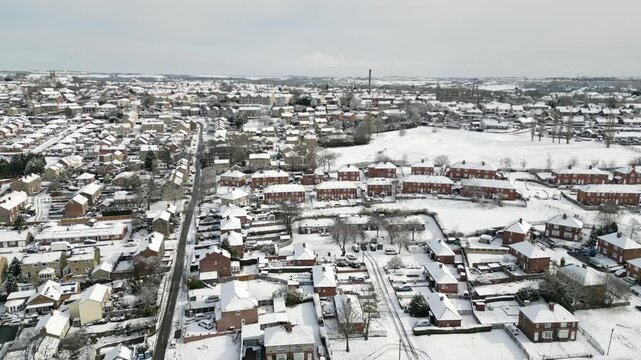 Aerial Drone Video Footage showing a snowy landscape in a suburban UK town.