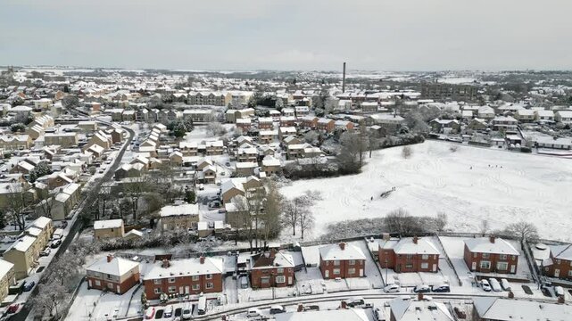 Aerial Drone Video Footage showing a snowy landscape in a suburban UK town.