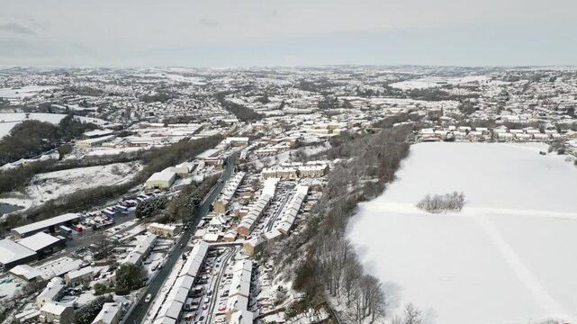 Aerial Drone Video Footage showing a snowy landscape in a suburban UK town.