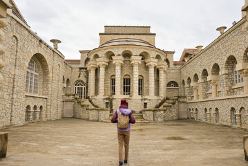 A female traveler with a backpack on her back inspects the attraction in Essentuki, the Semashko...