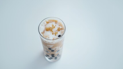 Close-up top view of bubble tea (boba tea) with black and golden tapioca pearls on a minimalist white background. Ideal for beverage or dessert-themed content.
