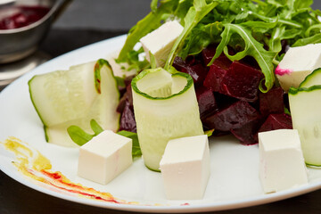 Fresh beetroot salad with feta cheese, cucumber, and arugula, perfect for a light and healthy meal