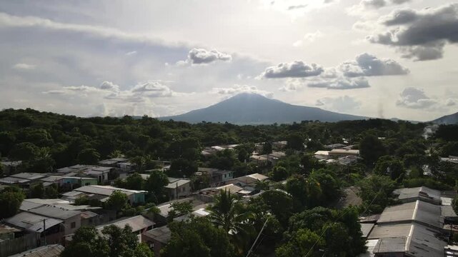 Ciudad con volc&aacute;n y nubes