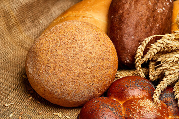 Assortment of freshly baked bread loaves with wheat stalks, tradition and artisanal baking