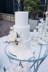 Sweet white cake on the background of a wedding arch for brides.