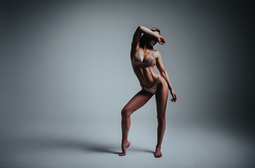 Young slim fitness woman in lingerie studio posing