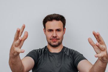 Fototapeta premium Young man holding something big hand sign portrait on white background