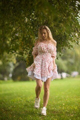 A Beautiful and Elegant Young Woman in a Lovely Summer Dress Posing Gracefully Outdoors