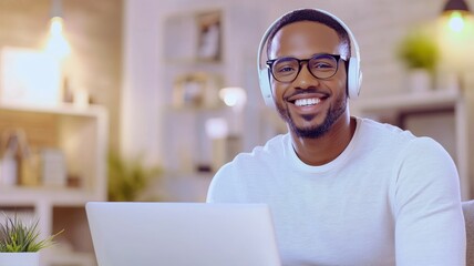 A man wearing glasses and headphones is smiling at the camera