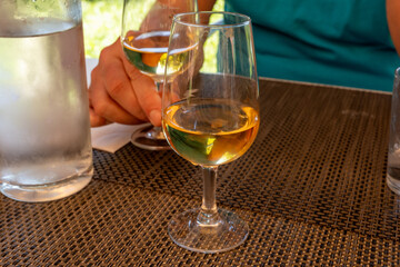 Tasting of Bordeaux white wine in Sauternes, left bank of Gironde Estuary, France. Glasses of white sweet French wine served in restaurant
