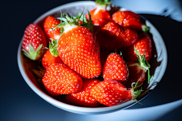 Plate with french organic red ripe sweet strawberries Fraises de Plougastel, harvested in France