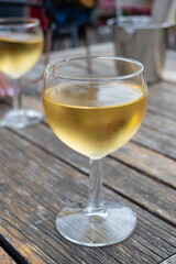 Tasting of Bordeaux white wine in Sauternes, left bank of Gironde Estuary, France. Glasses of white sweet French wine served in outdoor restaurant