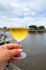 Tasting of Bordeaux white wine, right bank of Gironde Estuary, France. Glasses of white sweet French wine served in outdoor restaurant on oysters farm in Gujan-Mestras, Arcachon bay