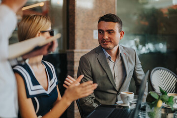 Business professionals gather outside for a casual meeting, exchanging ideas and collaborating over coffee, fostering teamwork and communication.