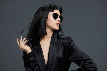 Woman, black suit, sunglasses a confident woman in a sleek black suit and stylish sunglasses poses...