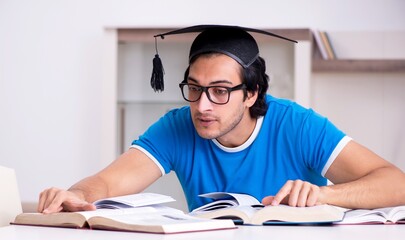 Young handsome student studying at home
