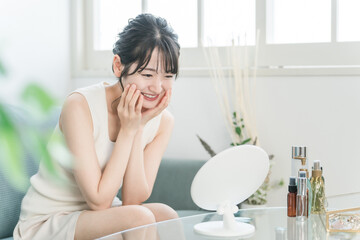 自宅でスキンケアする笑顔のアジア人女性
