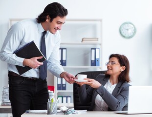 Old female boss and young male employee in the office