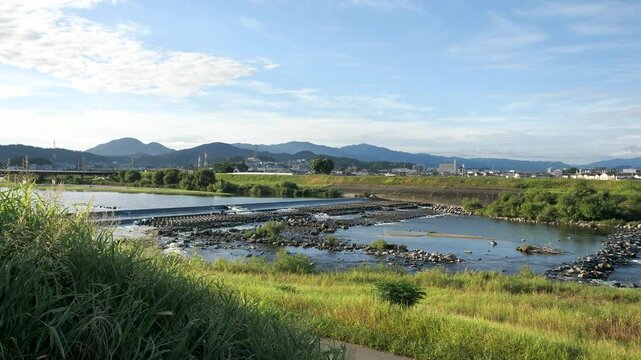 真夏の大和川柏原堰堤と山々の風景