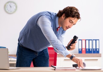 Young handsome employee working in the office