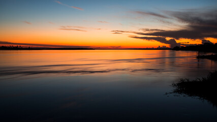 Golden hour over calm river and horizon