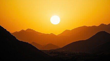 Golden sun setting behind distant mountains, with ample copy space.