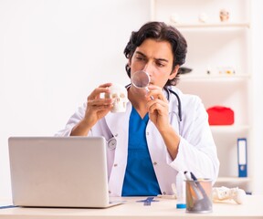 Young male doctor with human's skull