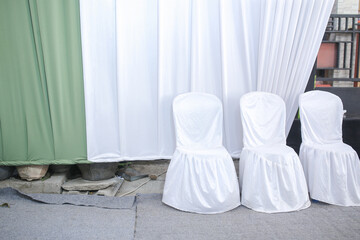 green and white wedding curtains and there are 3 wedding guest chairs
