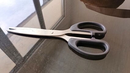Obraz premium Stainless Steel Scissors on Desk with Reflection on Glass Surface