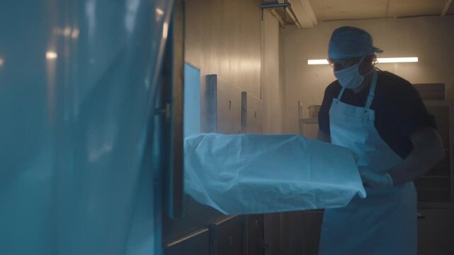 A Mortician taking the body out from the freezer
