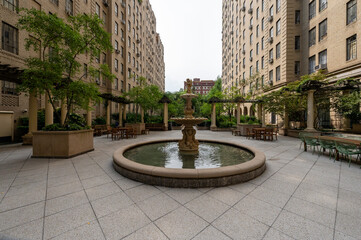 A beautifully designed urban courtyard nestled between historic brick buildings in New York City....