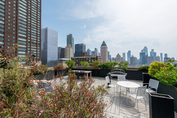 This striking New York City photo captures the contrast between towering modern skyscrapers and historic brick buildings, all viewed from a rooftop perspective. The image highlights the architectural 