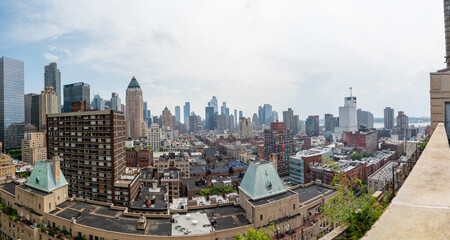 Obraz premium This striking New York City photo captures the contrast between towering modern skyscrapers and historic brick buildings, all viewed from a rooftop perspective. The image highlights the architectural 