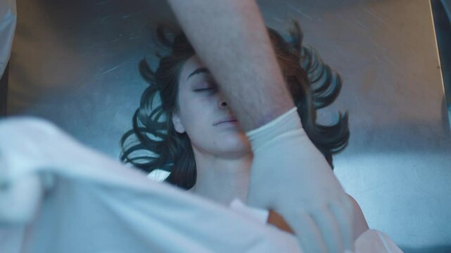 Directly above a female corpse on the table and mortician doing his job